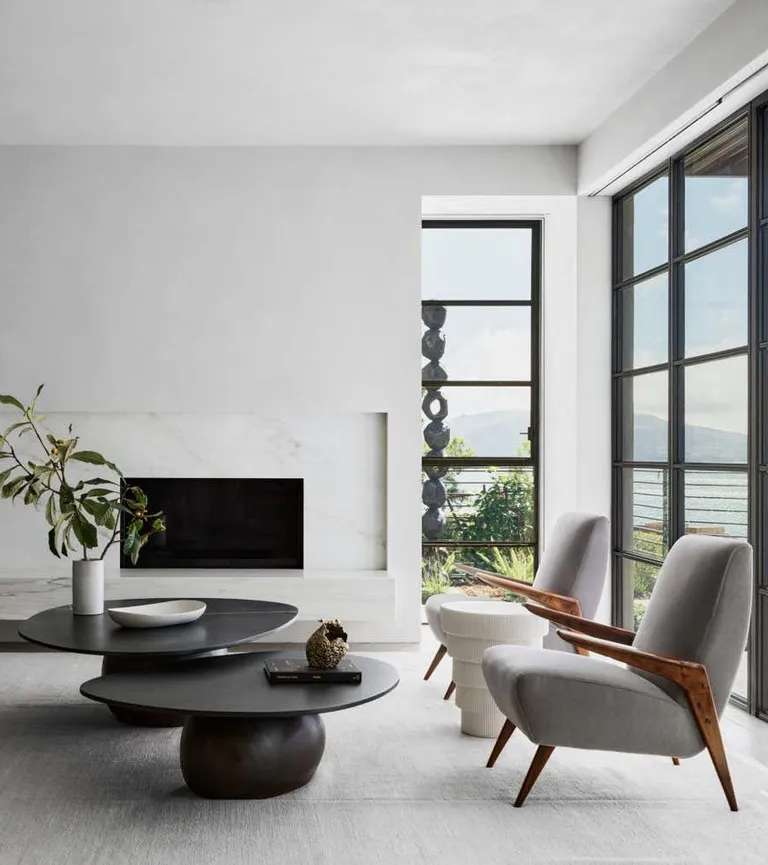 A living room with light grey chairs and a black coffee table