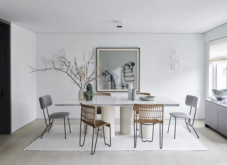 A dining room with grey chairs and wooden chairs