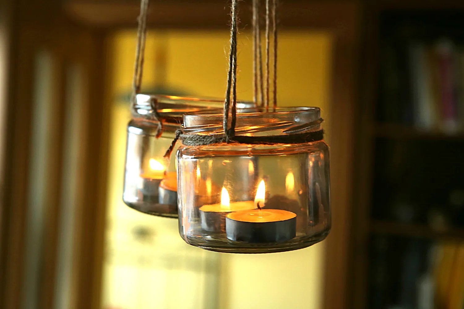 Hanging glass jars with tealight candles.